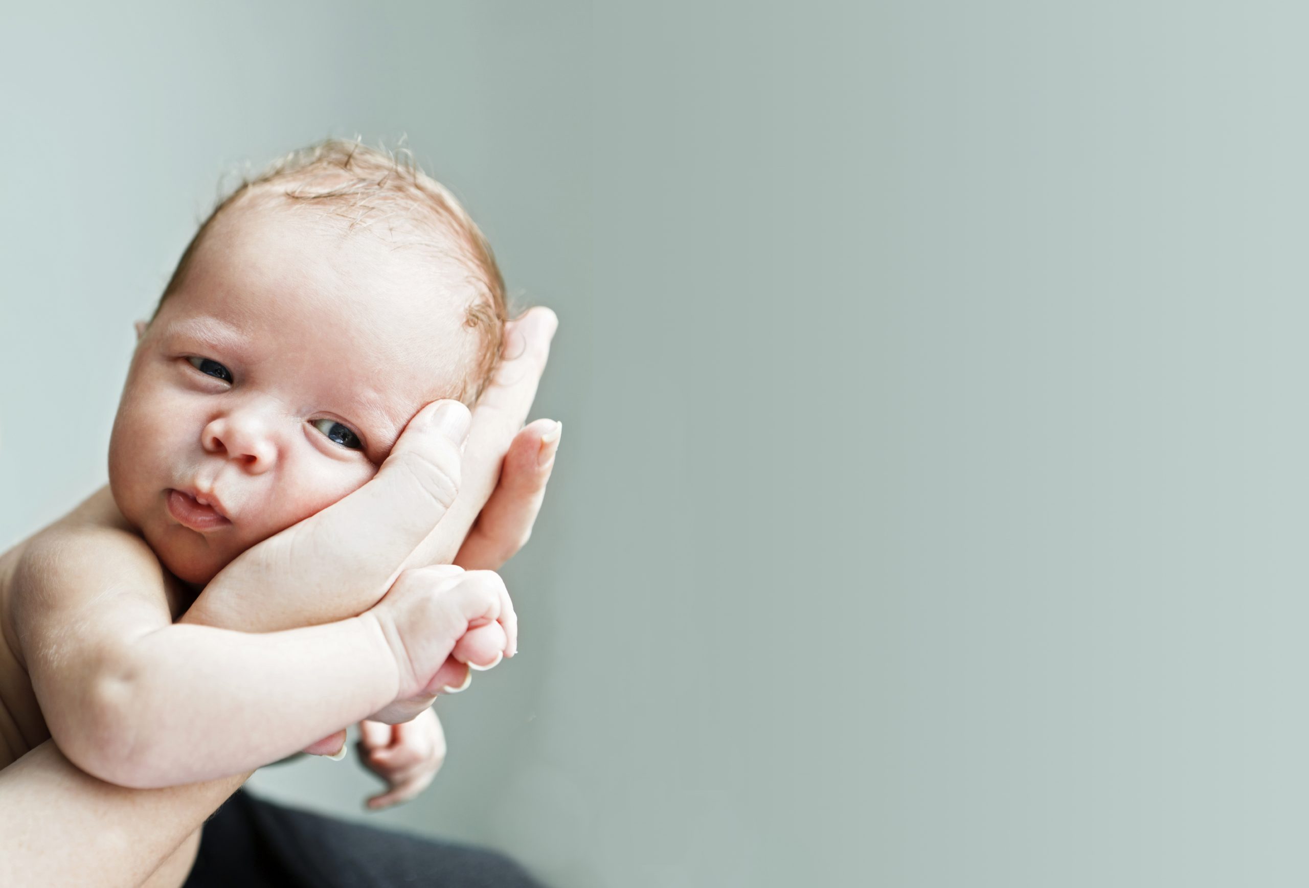A baby held in adult hands.